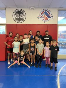Muay Thai coach guiding and inspiring a group of students during a dynamic training session at Adrenaline Martial Arts & Fitness in San Bernardino, CA.