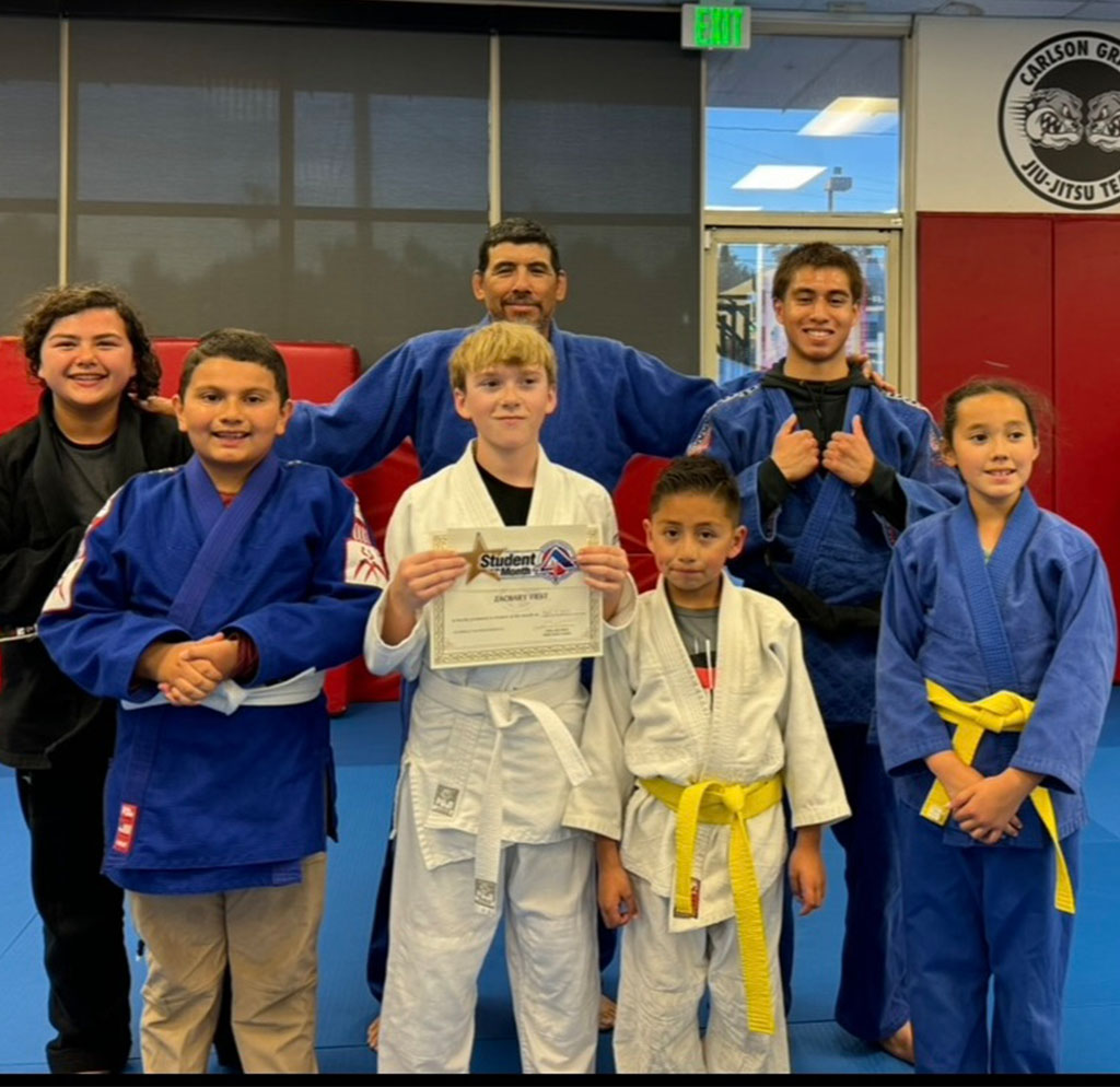 Paul Rodriguez celebrates his Judo promotion with Sensei Jesse Duran, Coach Gilberto Alonso, and fellow students at Adrenaline MMA & Fitness.