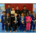Zackary Zavala holding Student of the Month certificate surrounded by kids in Jiu-Jitsu gis at Adrenaline Martial Arts San Bernardino